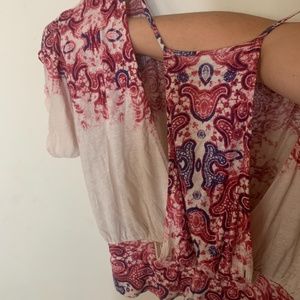 Free People open back crop top in cream with paisley pink and purple pattern.